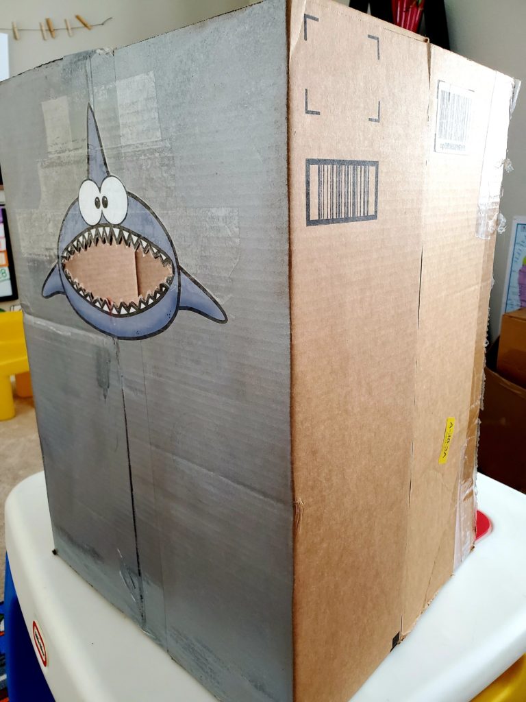 cardboard box with adorable image of a shark face with it's mouth cut out 