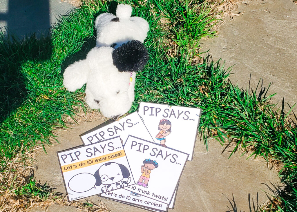Stuffed Dalmatian toy dog outside on the grass with task cards with exercises on each card