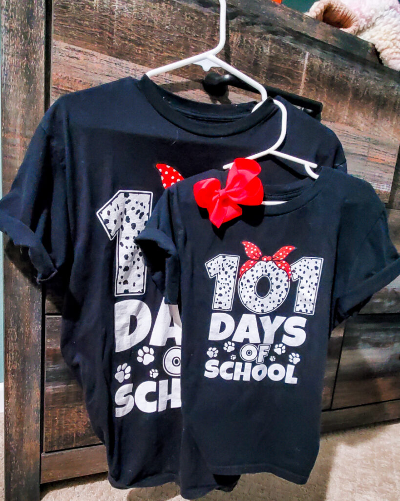 Black T-Shirt with 101 Days of School on the front with Dalmatian print and a red bow with white polka dots on the zero in one hundred and one