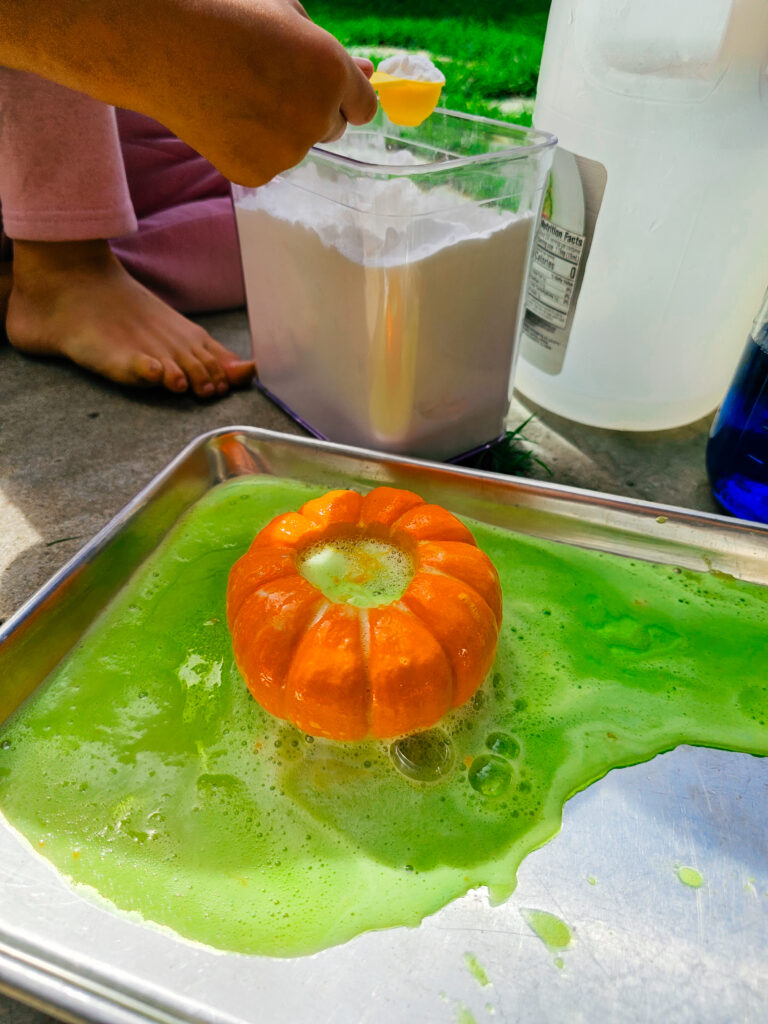 Mini pumpkin on a tray with green bubbly liquid all around it