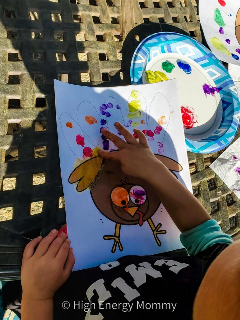 Cute Turkey crafts for kids paper with printed turkey and child finger printing feathers with paint