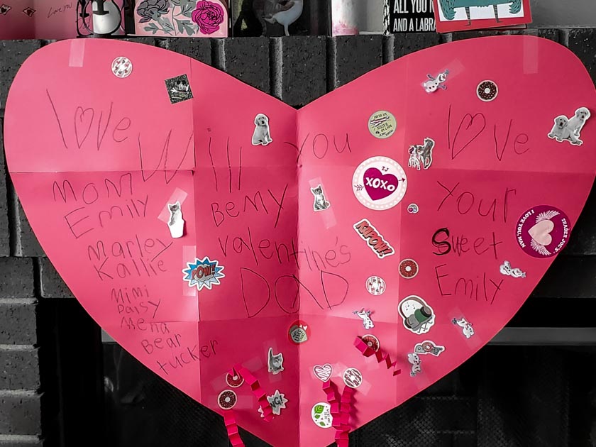 A huge red paper heart with various animal and valentine stickers on it and a message that reads will you be my valentine Dad